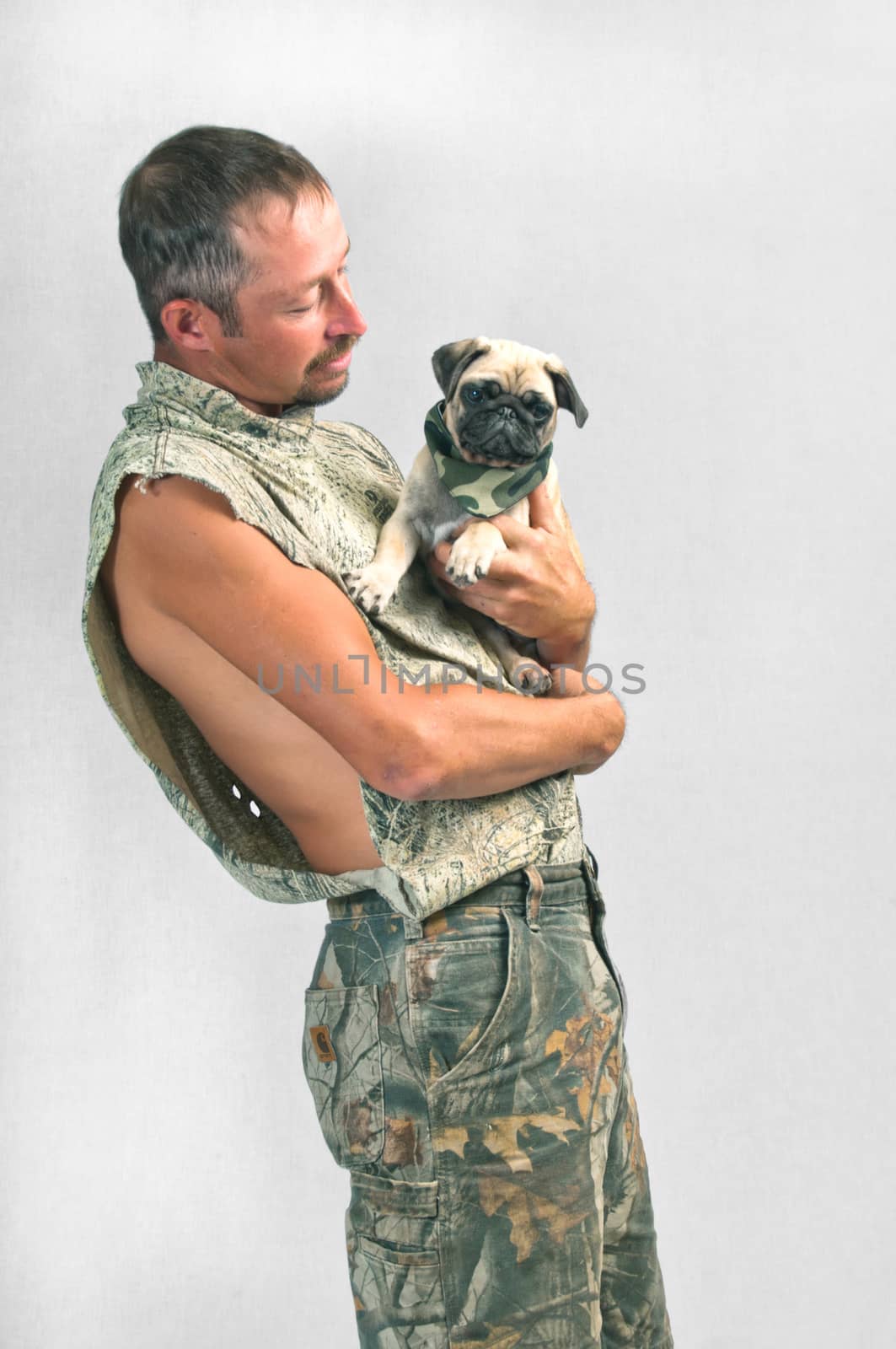 Young man holding the pet Pug he just rescued from the animal shelter.