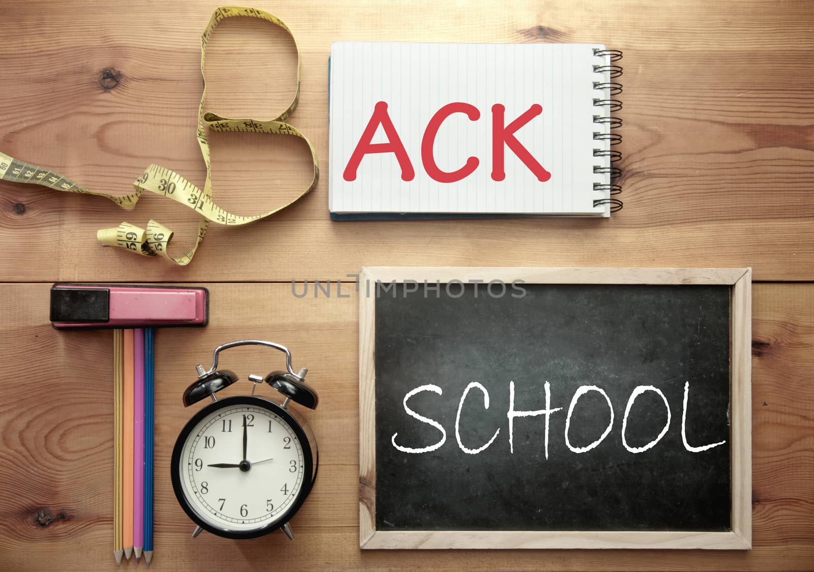 Back to school education background spelt using stationery objects including a clock, notepad and chalkboard 