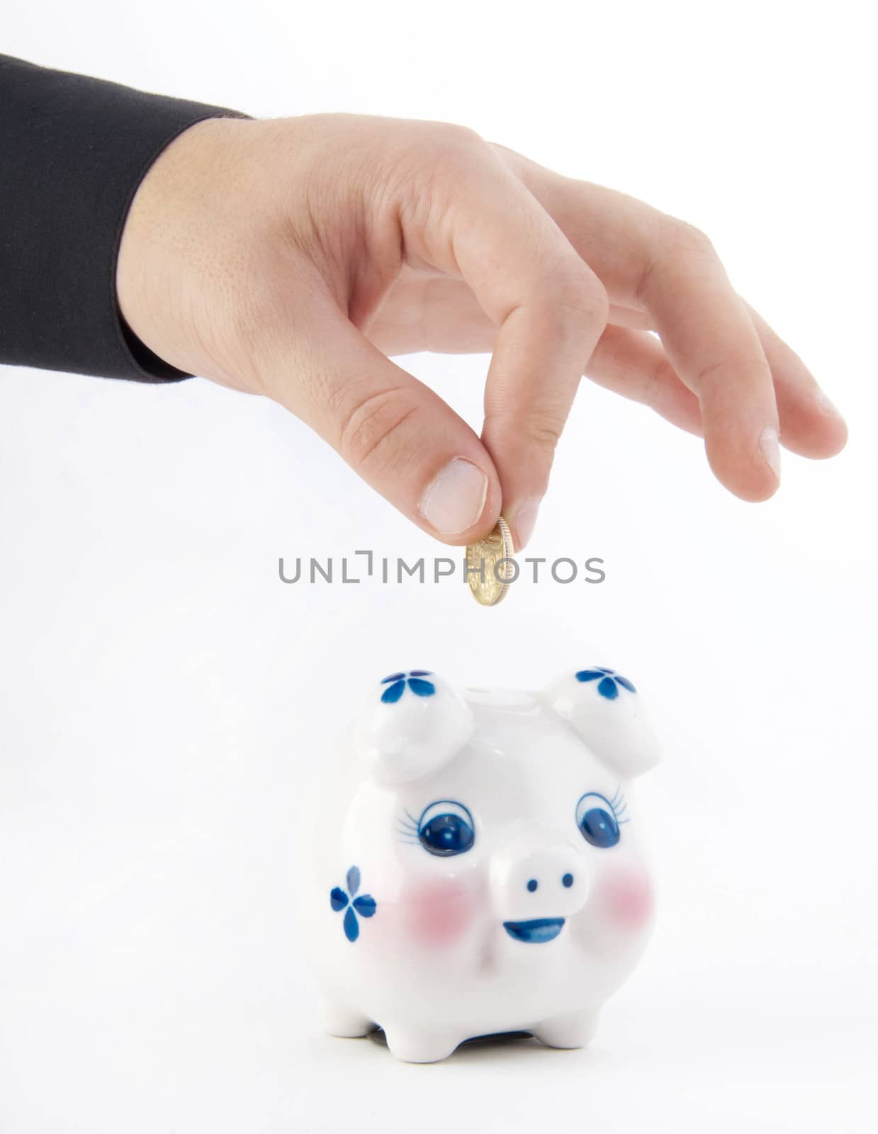 Hand inserting coin into piggy-bank