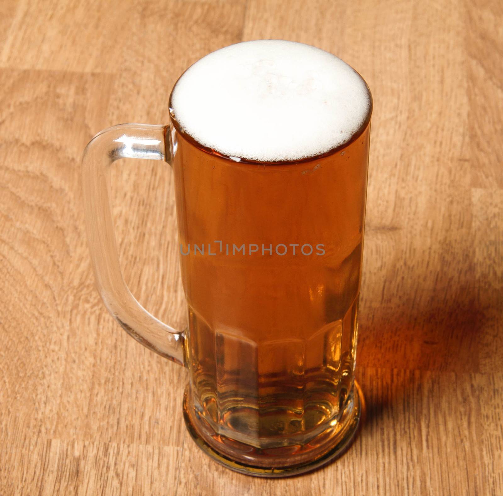 Single beer glass on wooden table