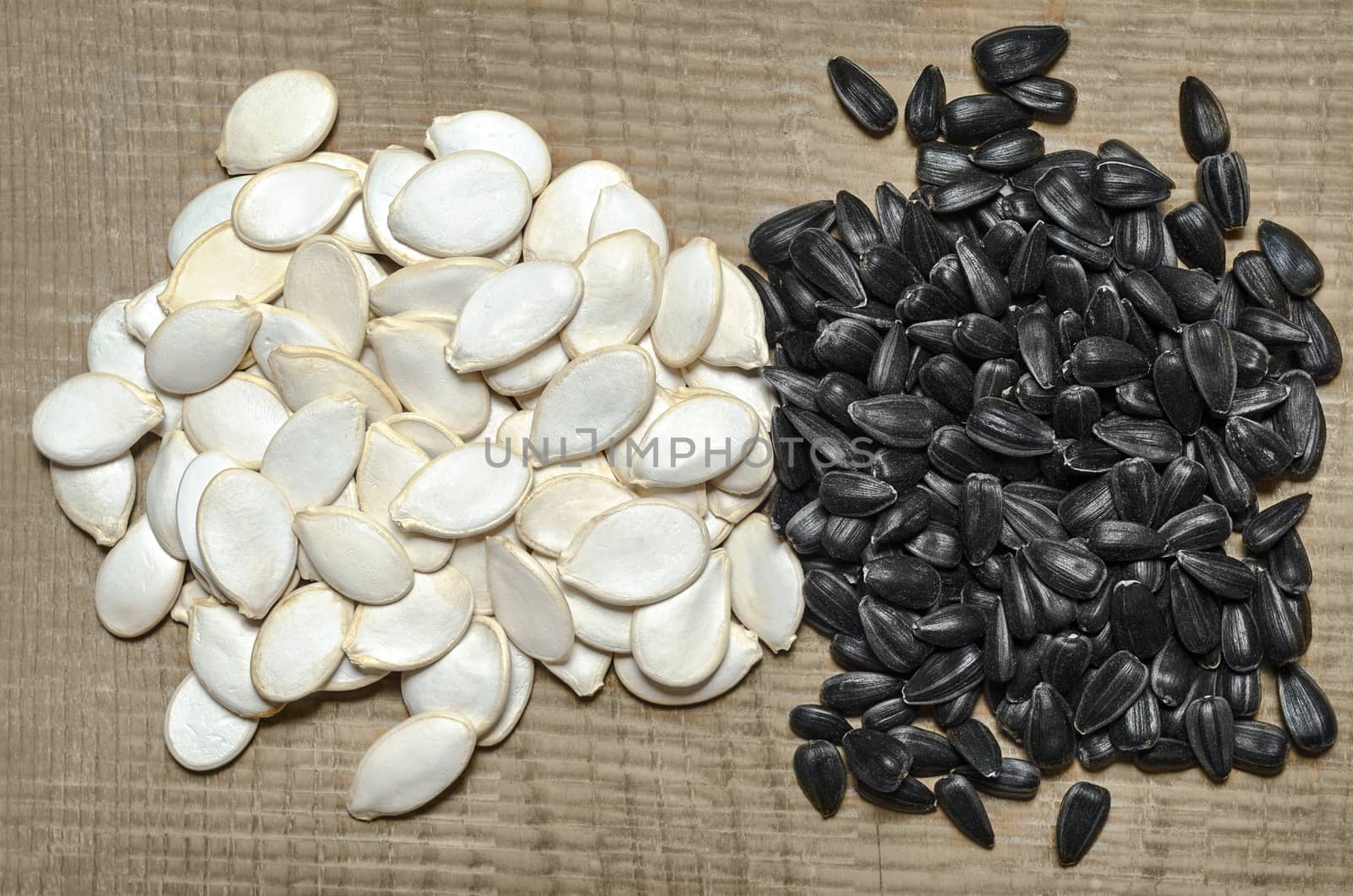 Pumpkin seeds and sunflower seeds, lying on the wooden background is not cleared
