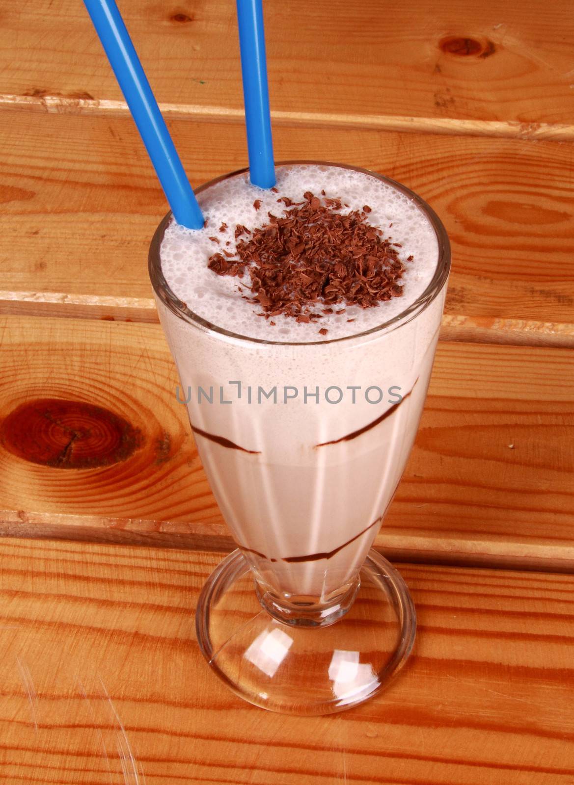 Milk cocktail and straw in goblet with chocolate