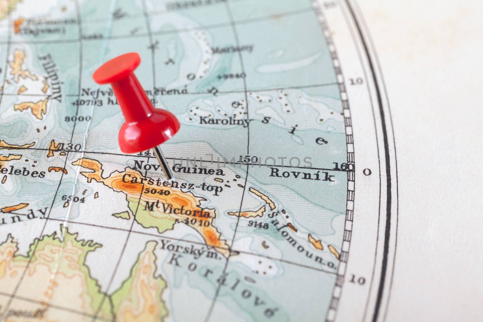 Red push pin showing the location of a destination point on a map. New Guinea
