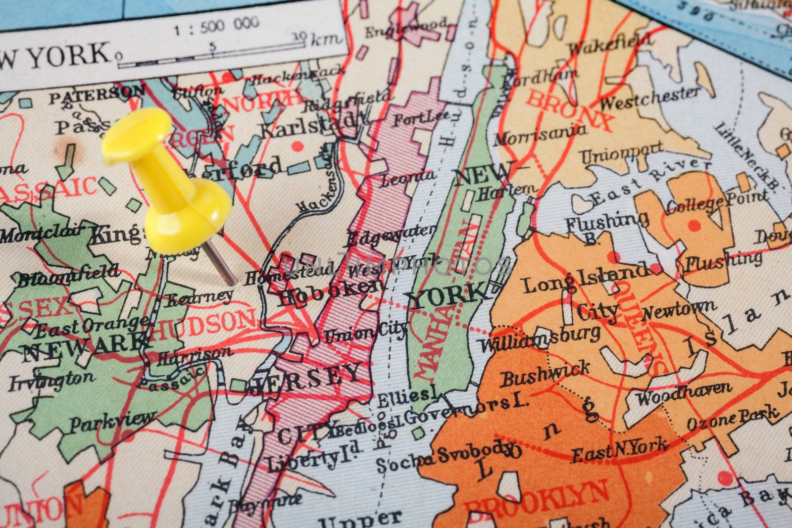 Red push pin showing the location of a destination point on a map. New York