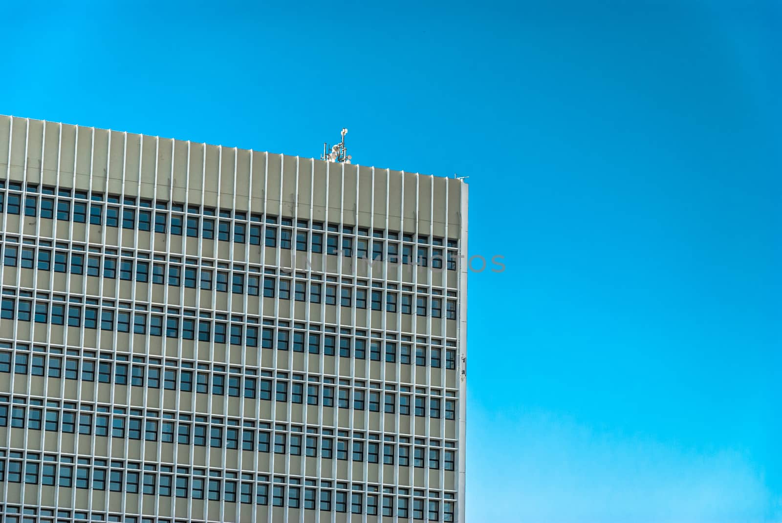 horizontal image of cement tall building with windows and the sky