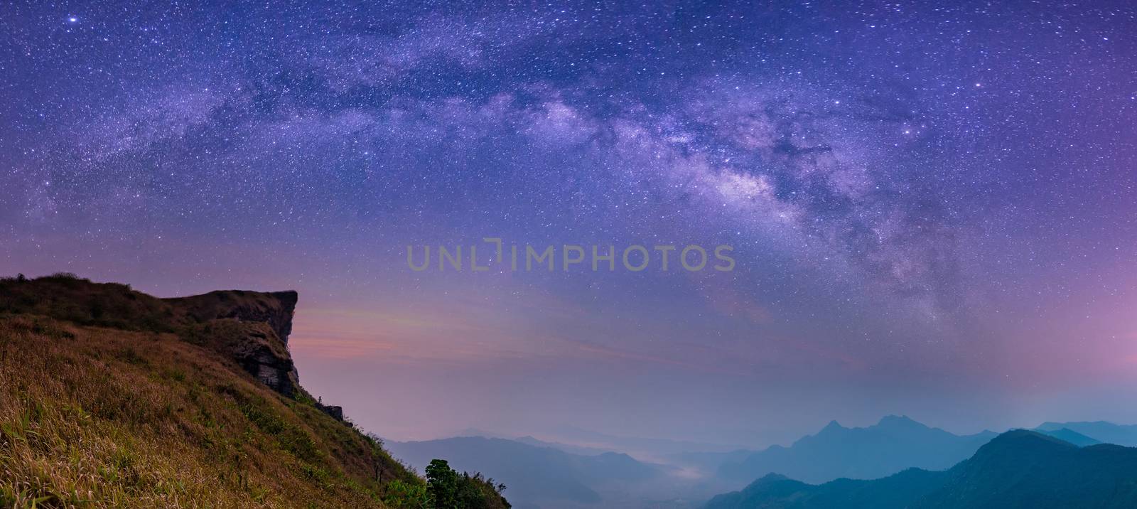 Abstract blurred landscape with Milky way galaxy Night sky with stars and silhouette of rock mountains. Phu Chi Fa View Point at Thoeng District, Chiang Rai Province,Thailand, Long exposure photograph
