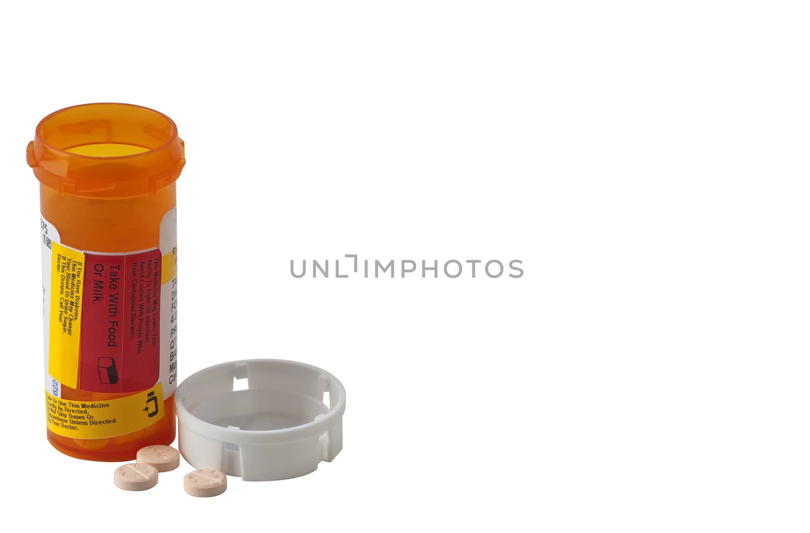 Pill bottle with child proof cap removed and pills on counter by rcarner