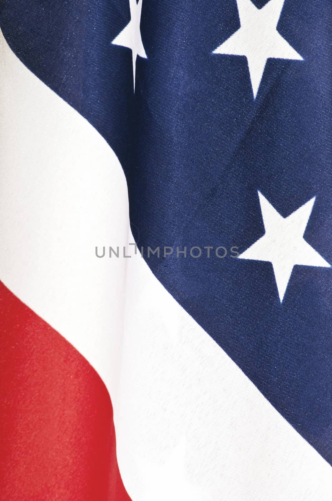 Closeup of an American flag showing the red, white and blue with some of the stars.