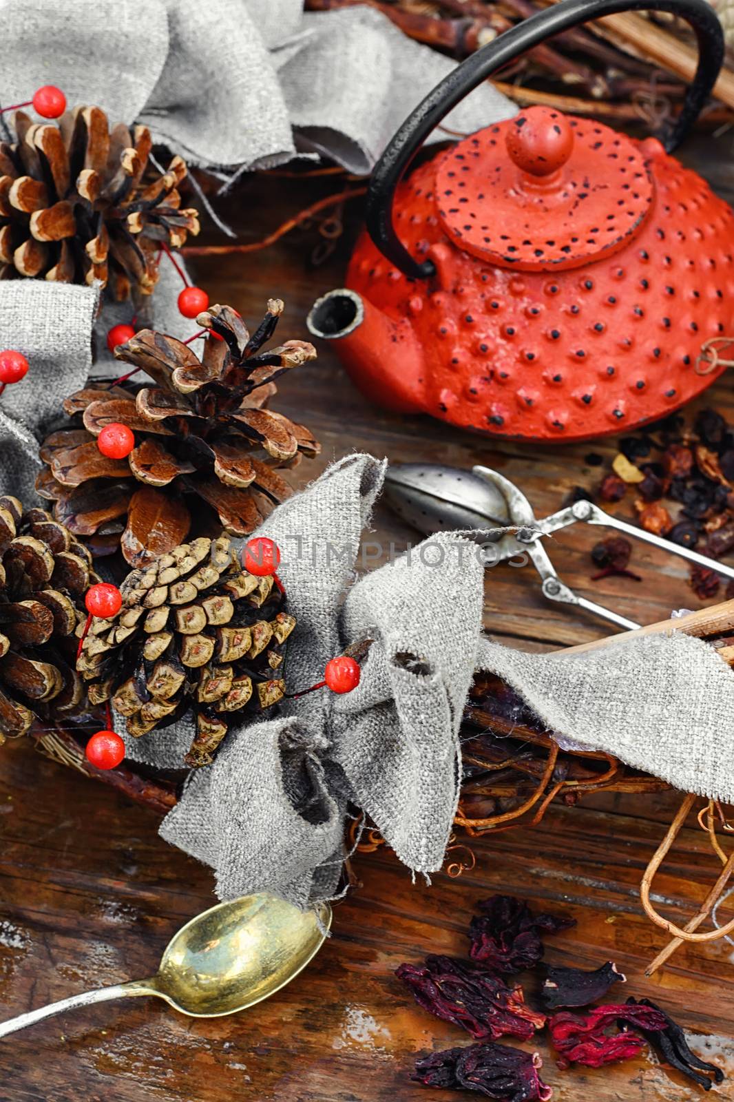 Red metal teapot,tea leaves and autumn pine cones