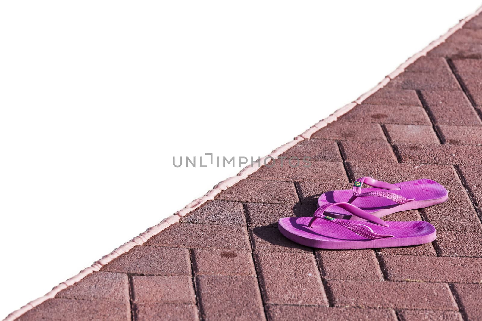 Purple flipflops on poolside in a sunny day in northern italy