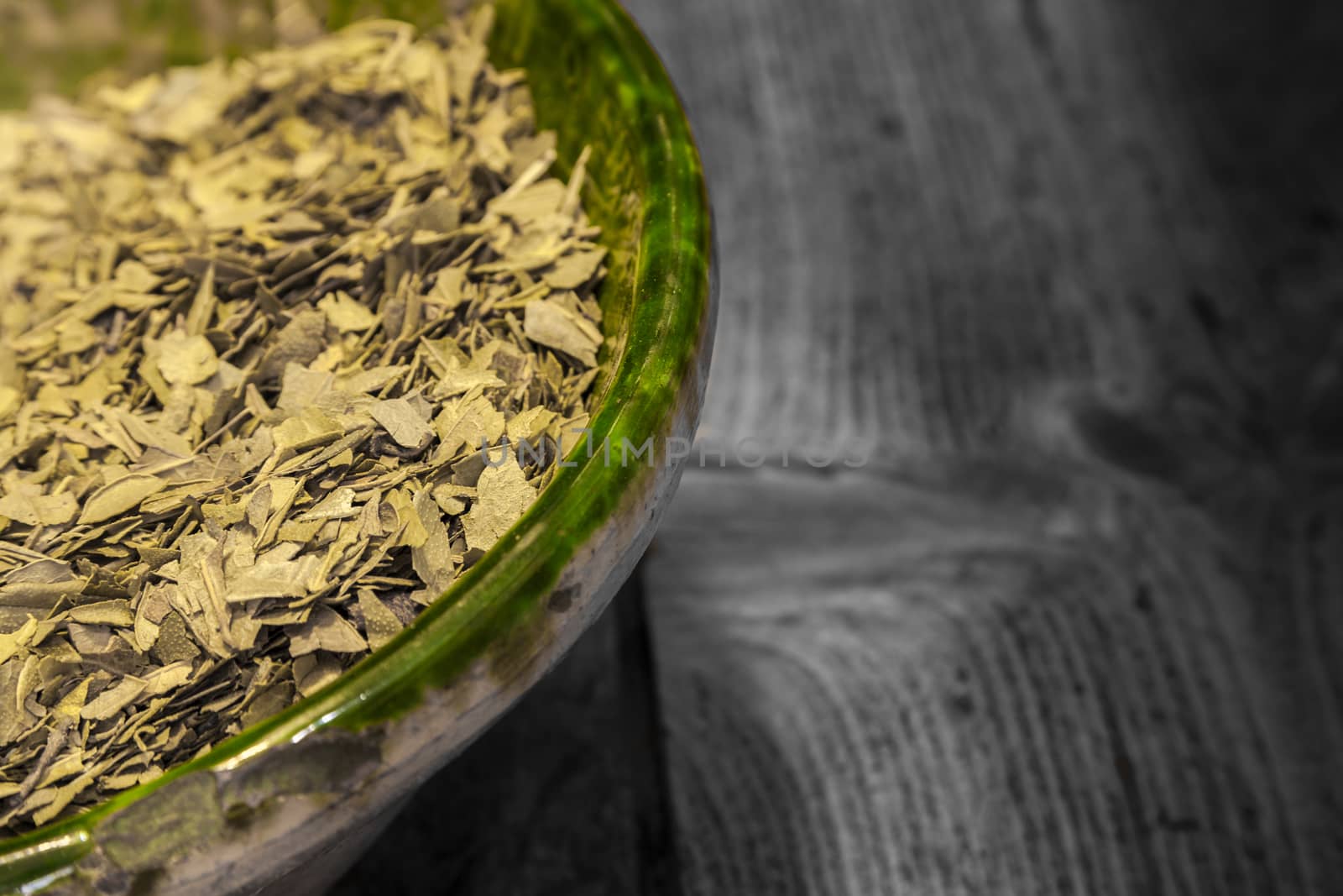 Dried green tea leaves in a green  glass jar