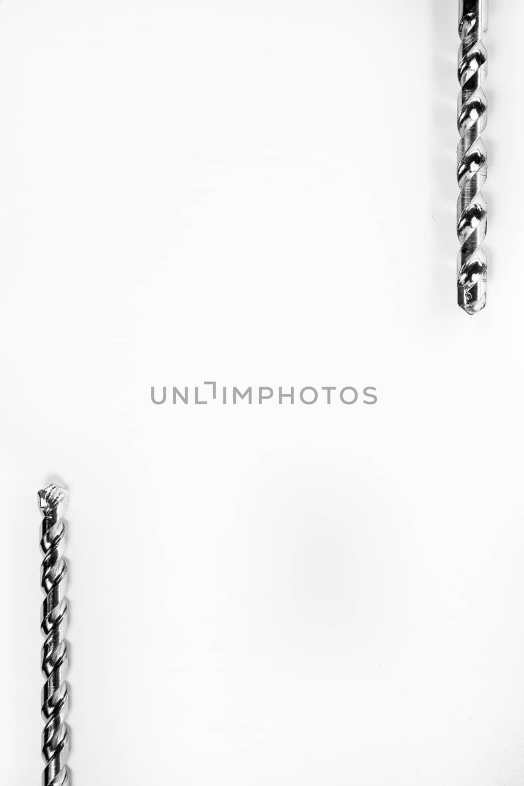 Drill bits of different sizes isolated over white background with copy space