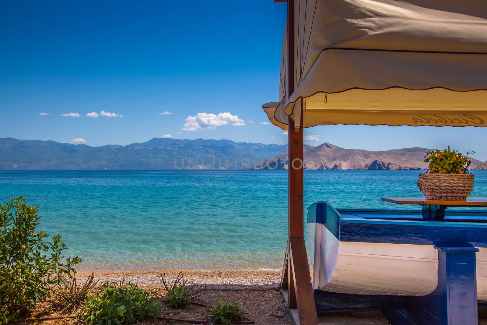 A boat used as a table in front of a suny tropical beach