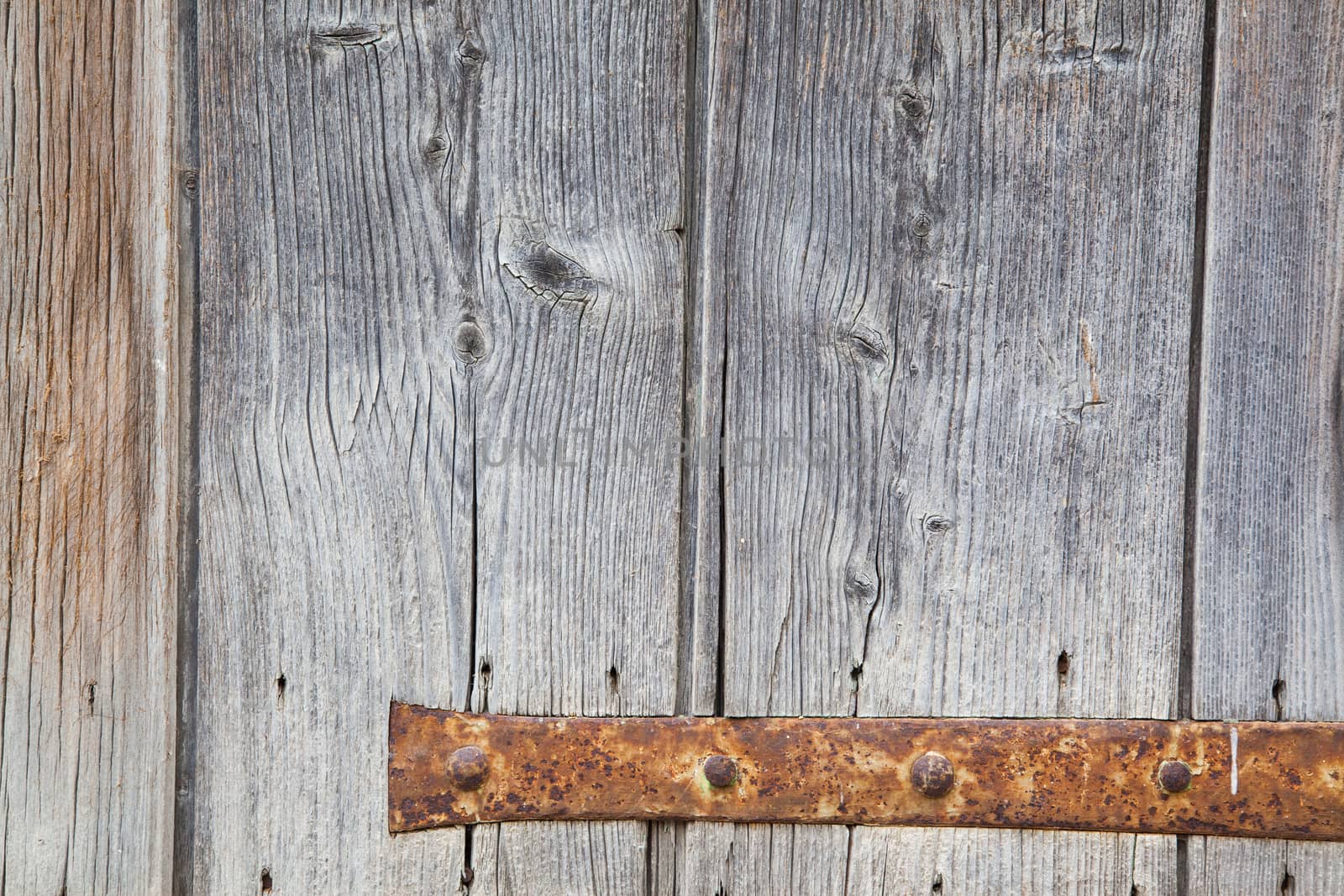 Weathered grey window with his rusty hinge
