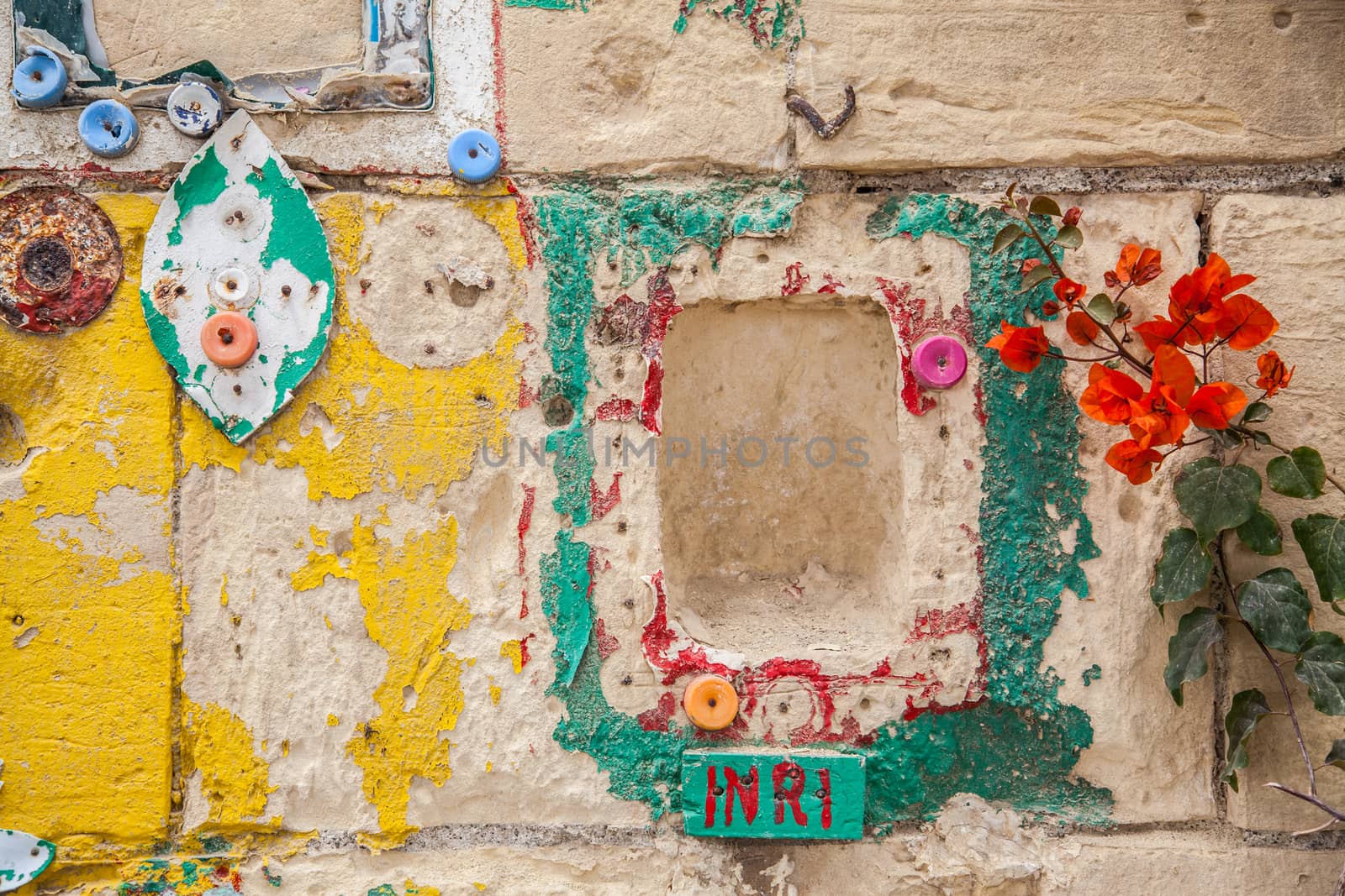 Hand painted wall with religious reference, bottle plugs and red flowers