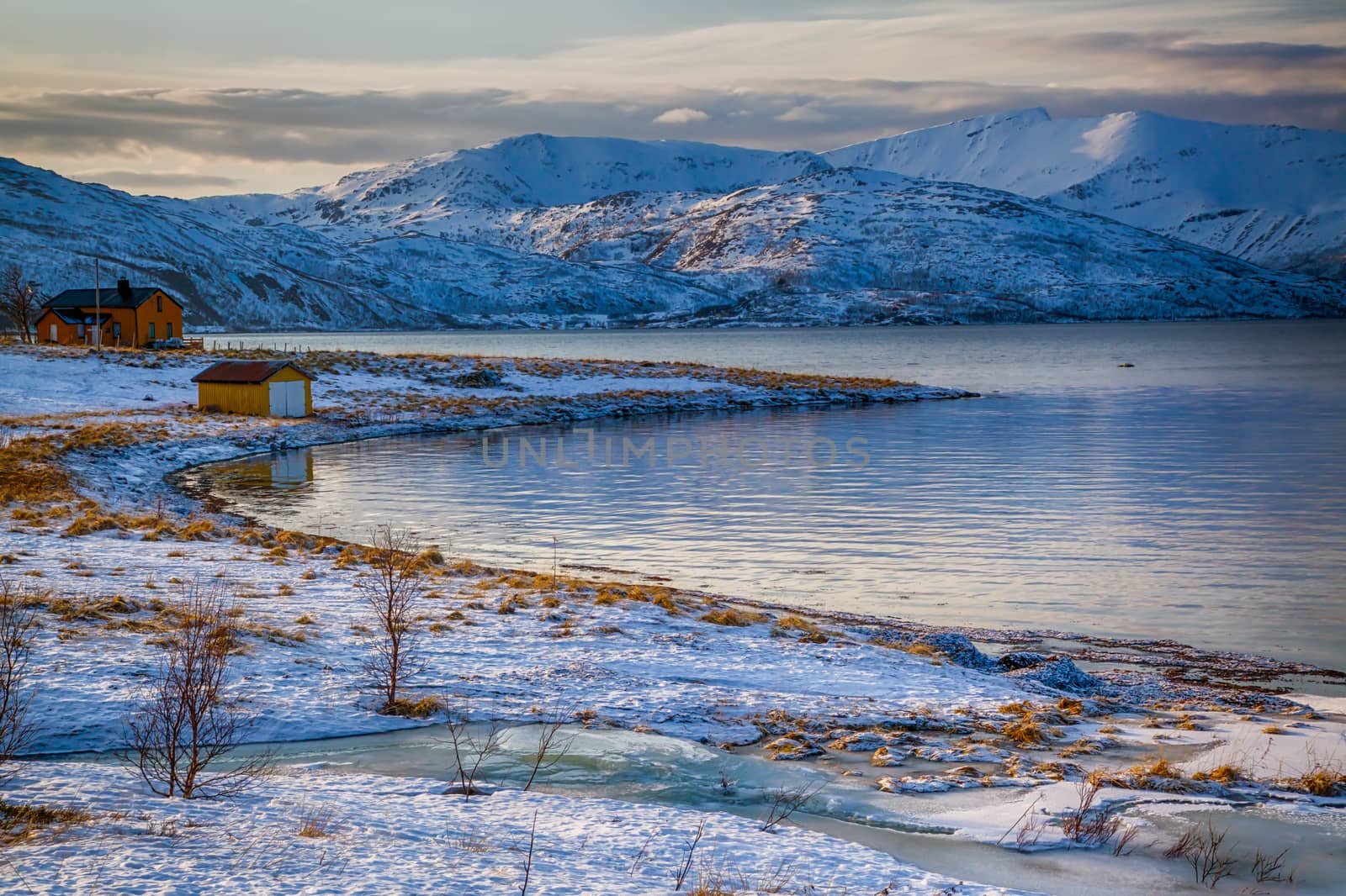 Isolated home and beach on a snowy lake