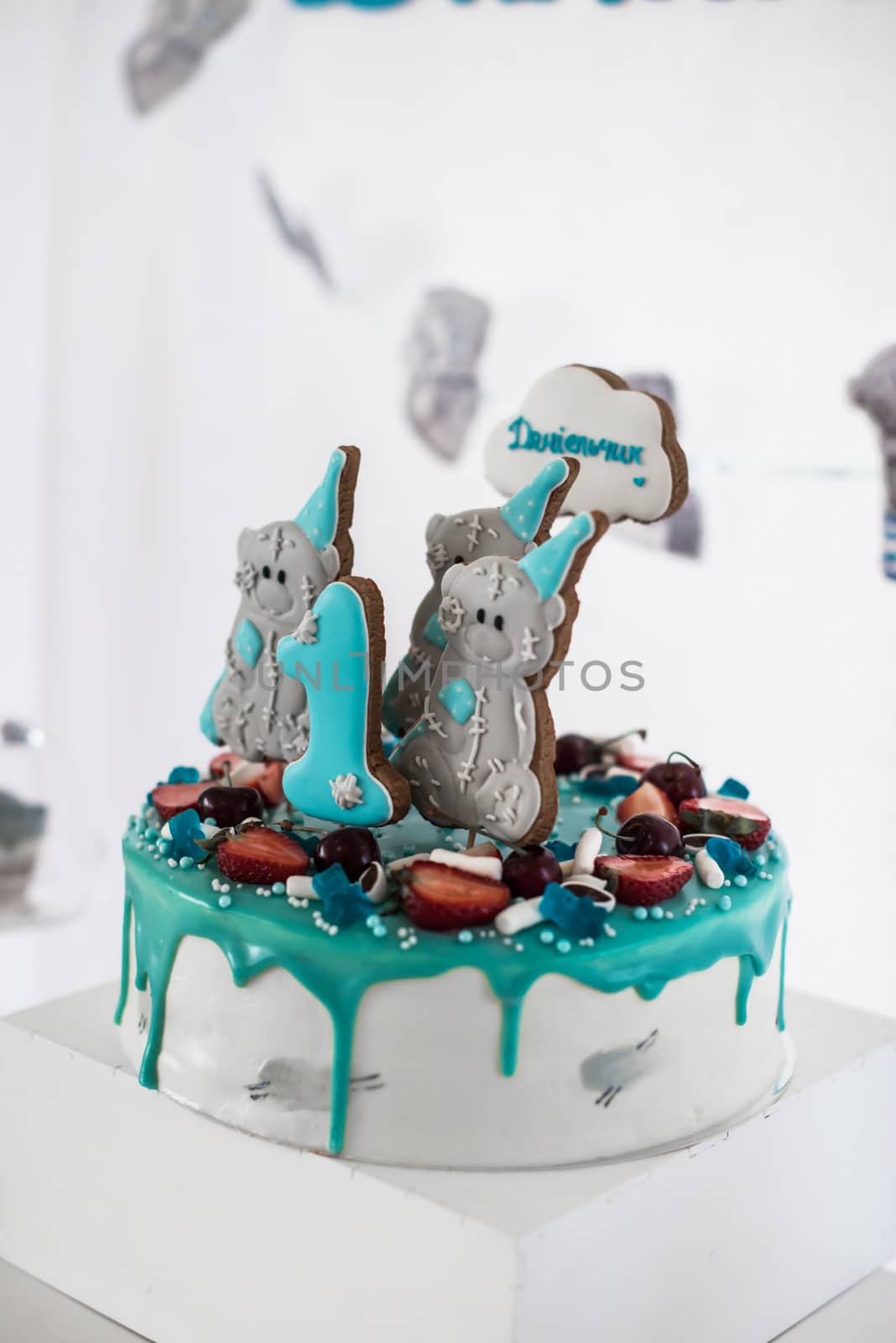 White cake decorated with blue fondant and cookies in the form of bears