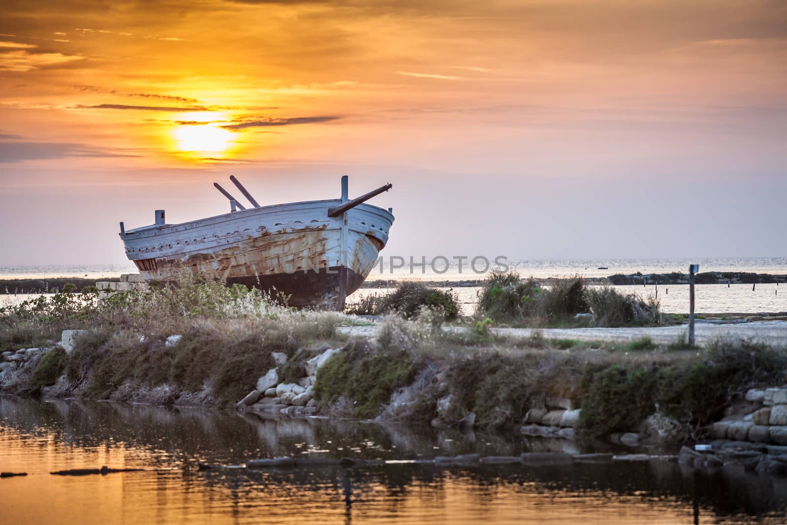 An old and weathered boat at the sicilian sunset