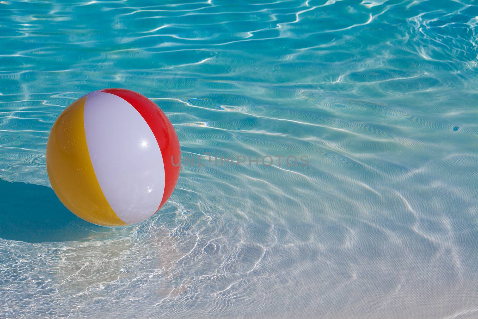 Inflatable colorful ball floating in a swimming pool