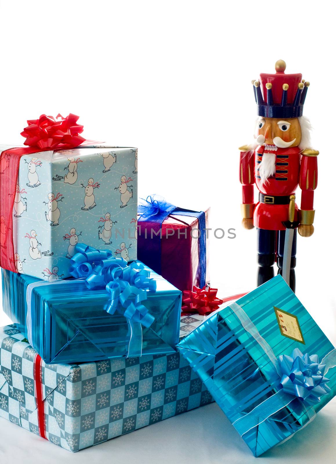 An  oversized nutcracker stands near a small pile of presents.