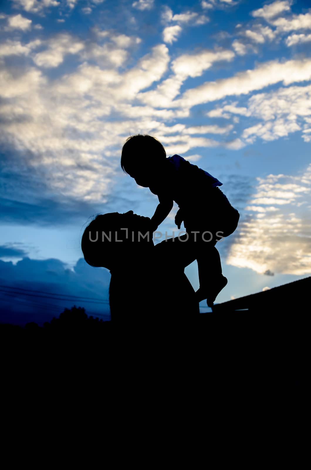 Silhouettes of the Thai women and child in the evening by worrayuth