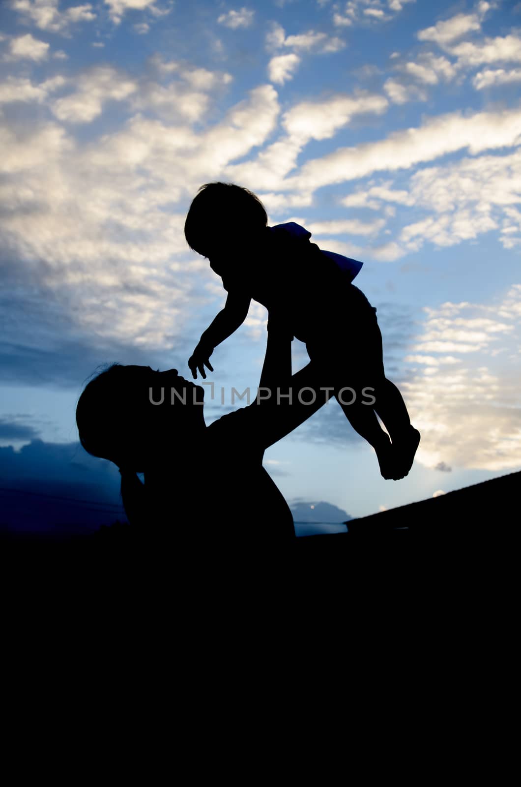 Silhouettes of the women and child in the evening by worrayuth