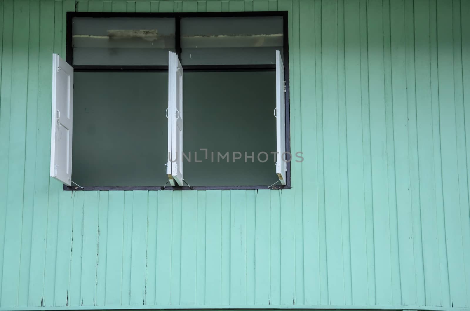 Windows with green wooden wall by worrayuth