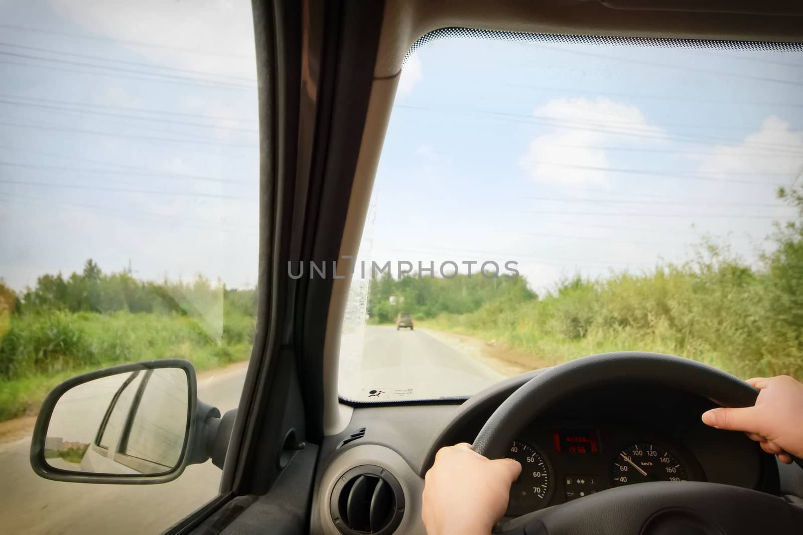 Woman driving, view inside a car on a road