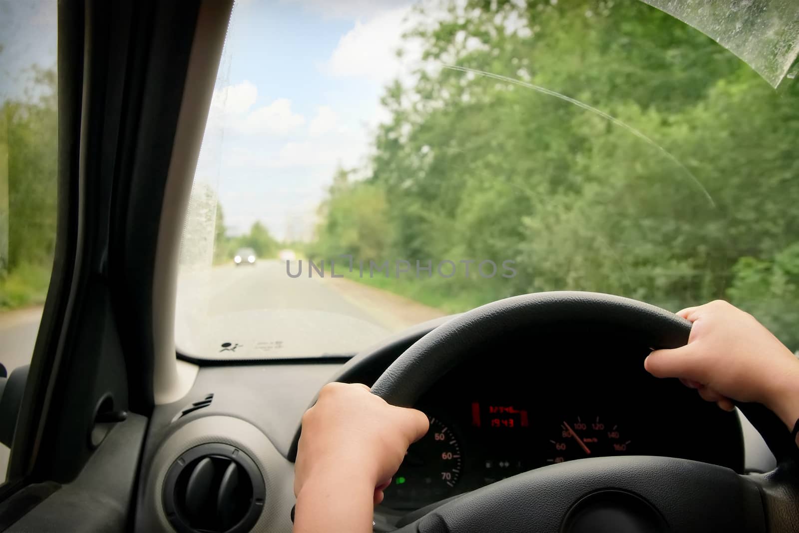 Woman driving, view inside a car on a road