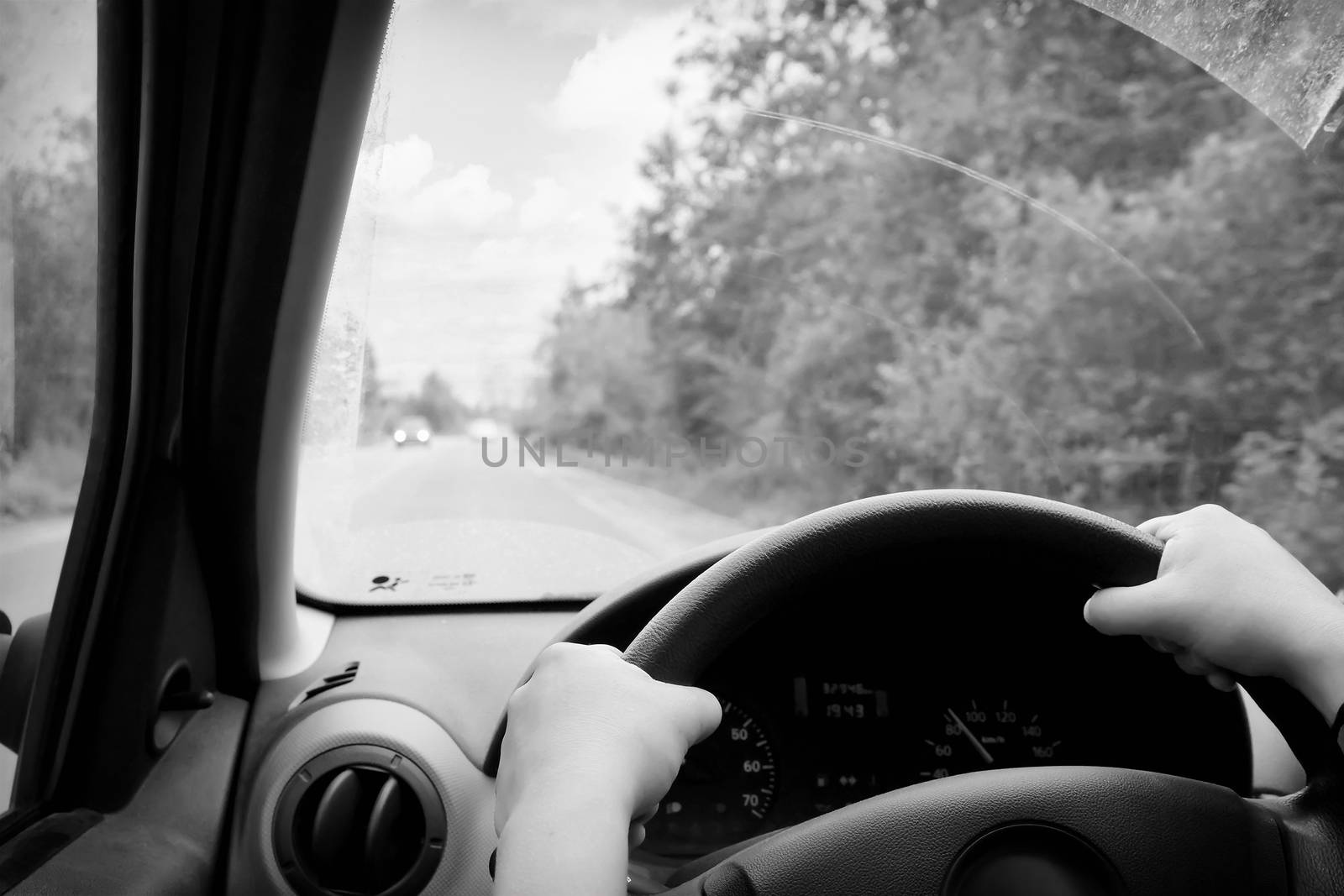 Woman driving, view inside a car on a road
