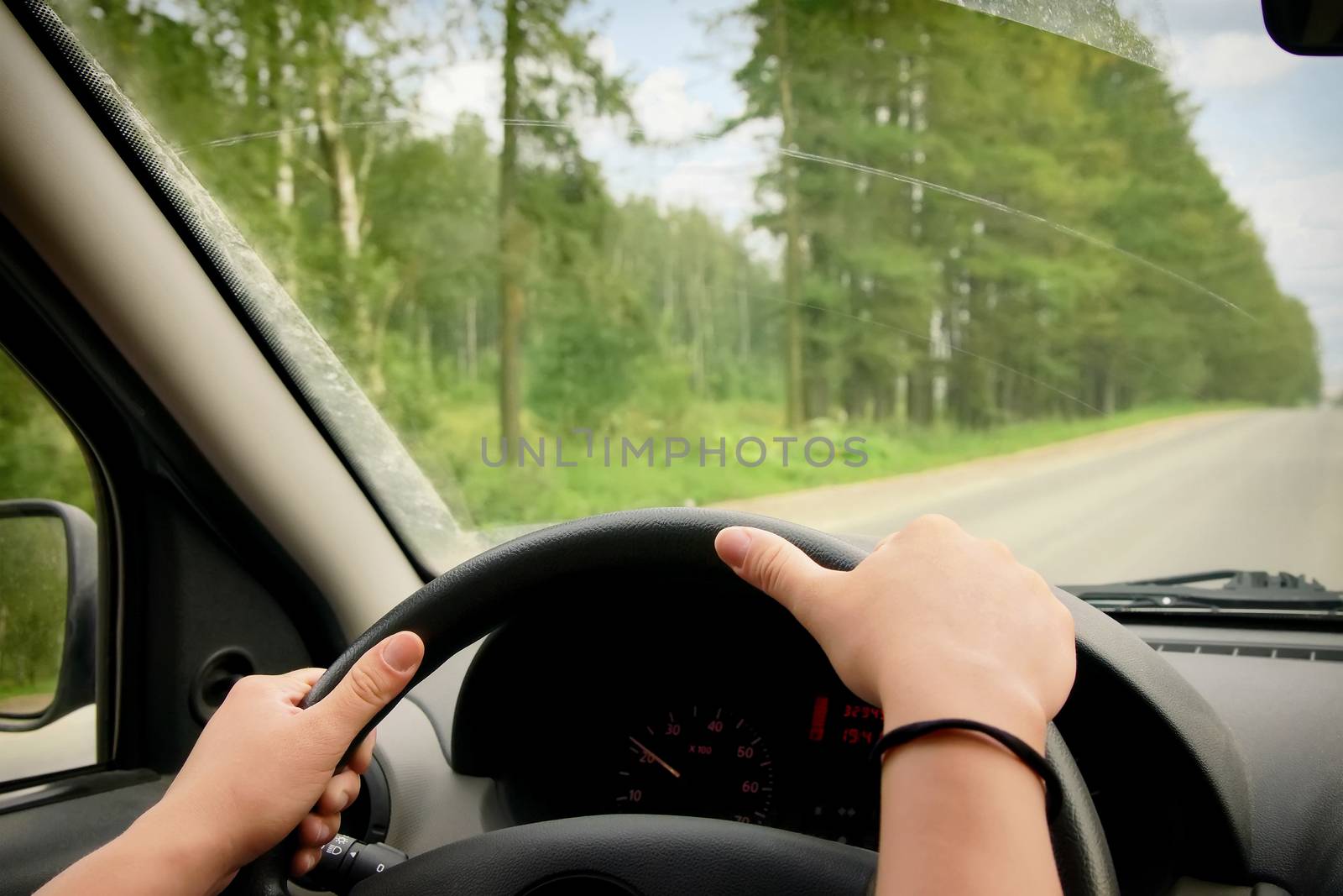 Woman driving, view inside a car on a road