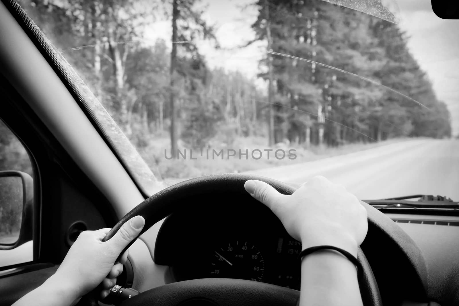 Woman driving, view inside a car on a road