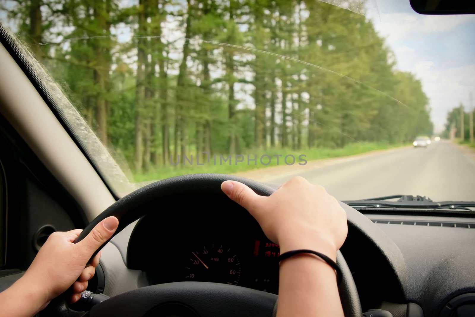 Woman driving, view inside a car on a road