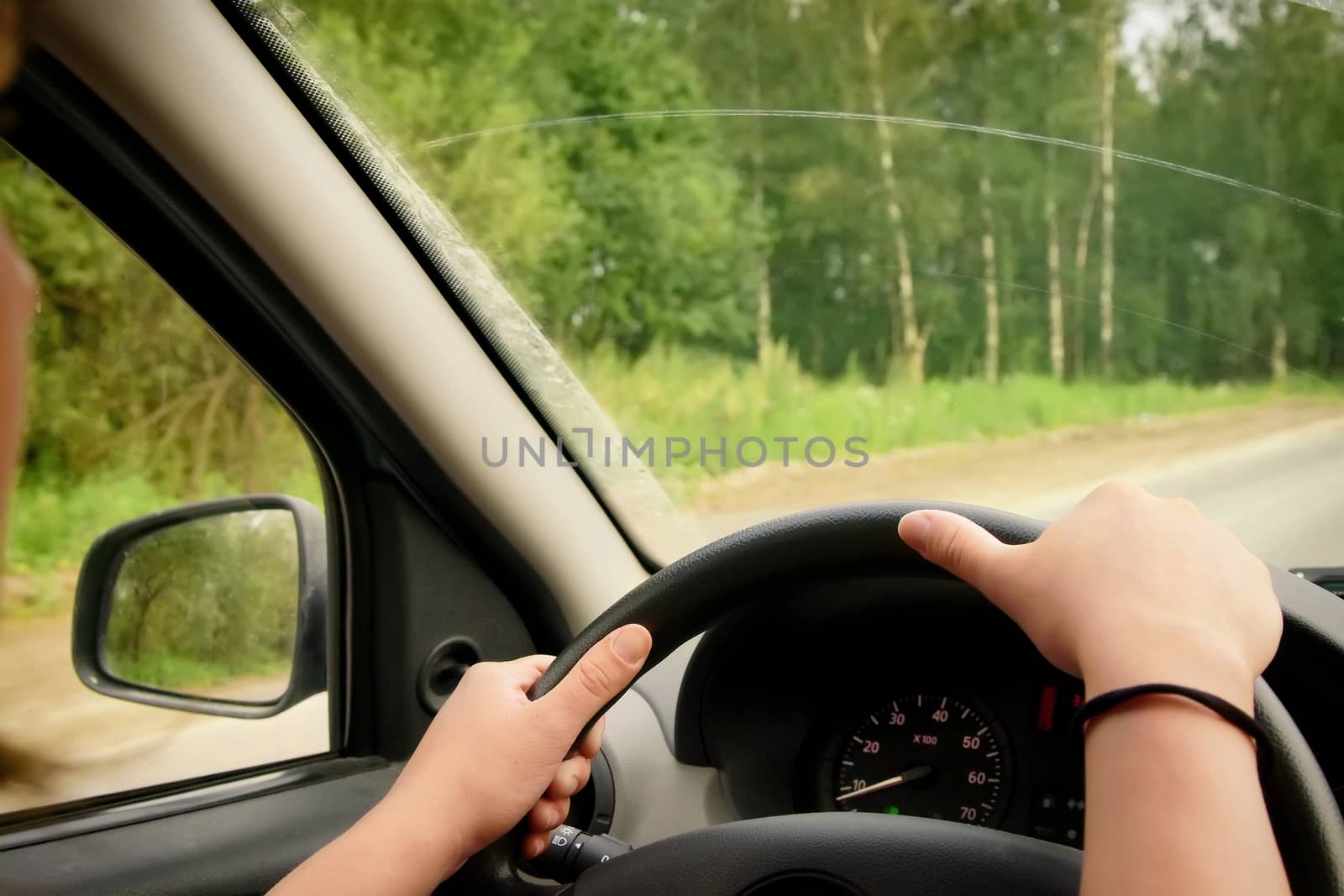 Woman driving, view inside a car on a road