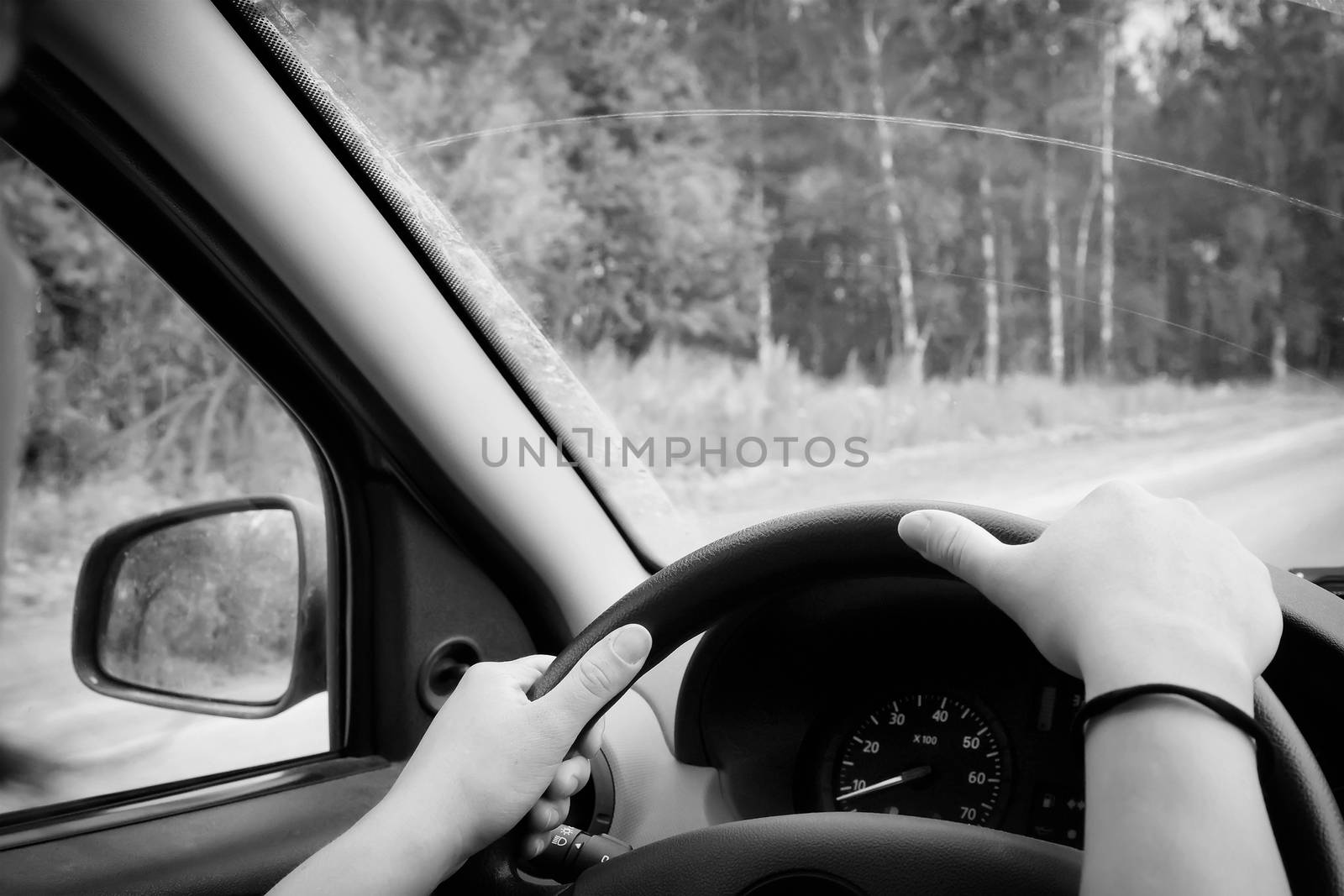 Woman driving, view inside a car on a road