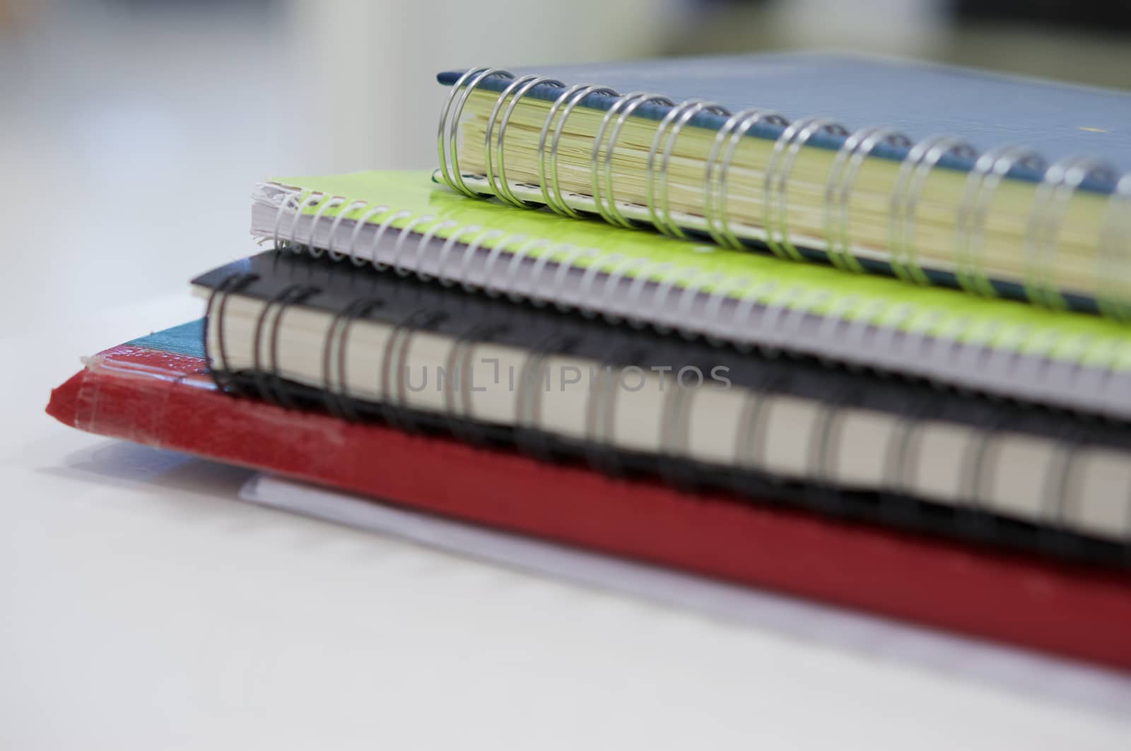 Stack of notebook and accounting note on white desk at office.