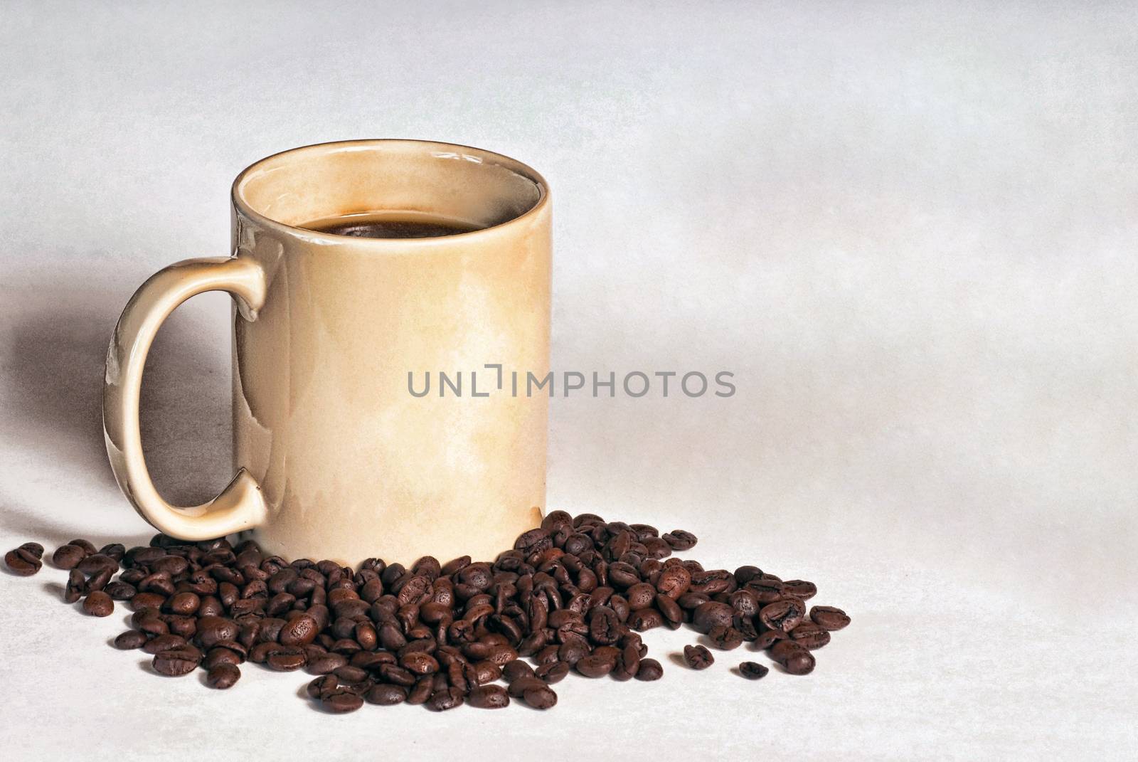 Cup of coffee surrounded by fresh unground coffee beans