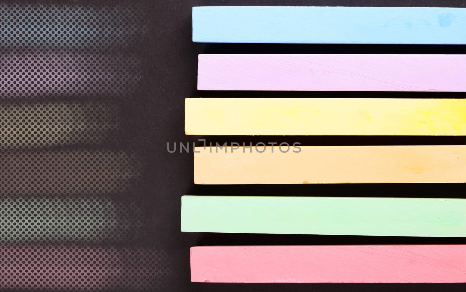 set of colored crayons on a black background