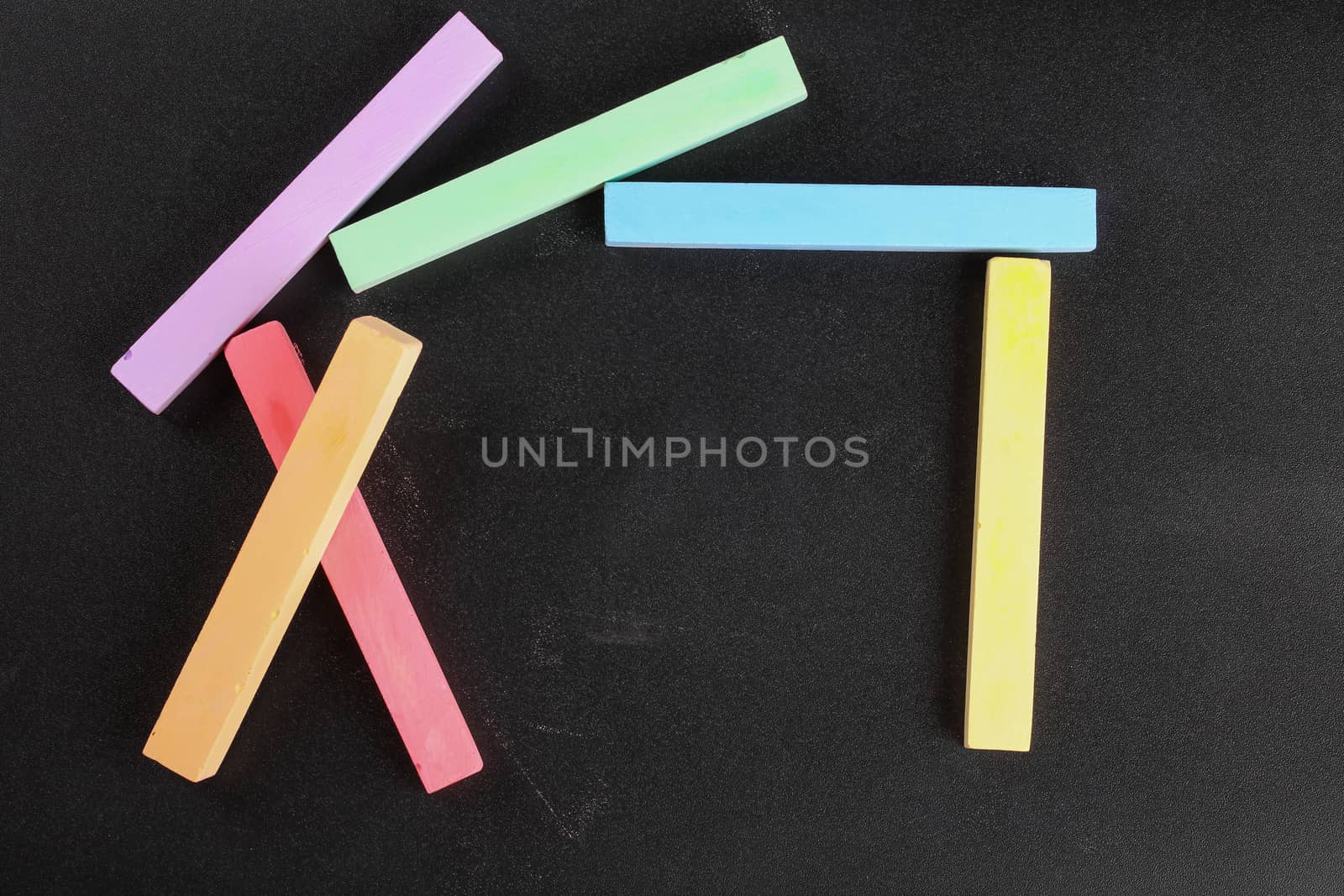 set of colored crayons on a black background