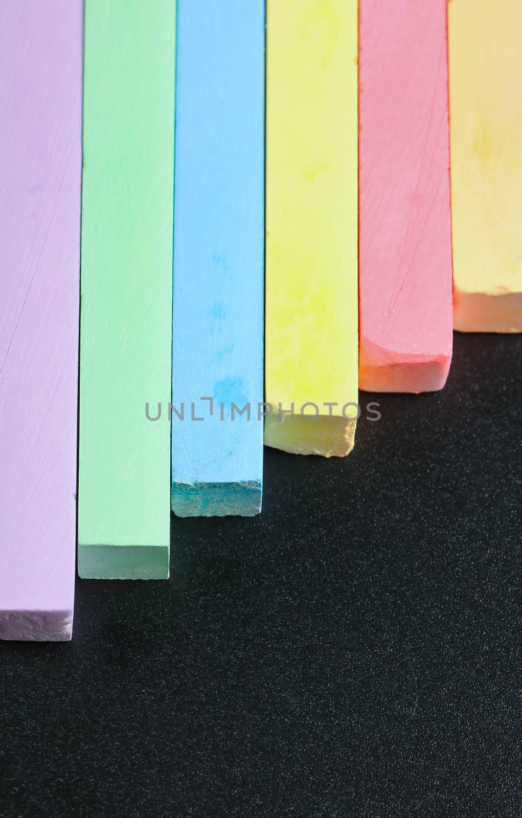set of colored crayons on a black background