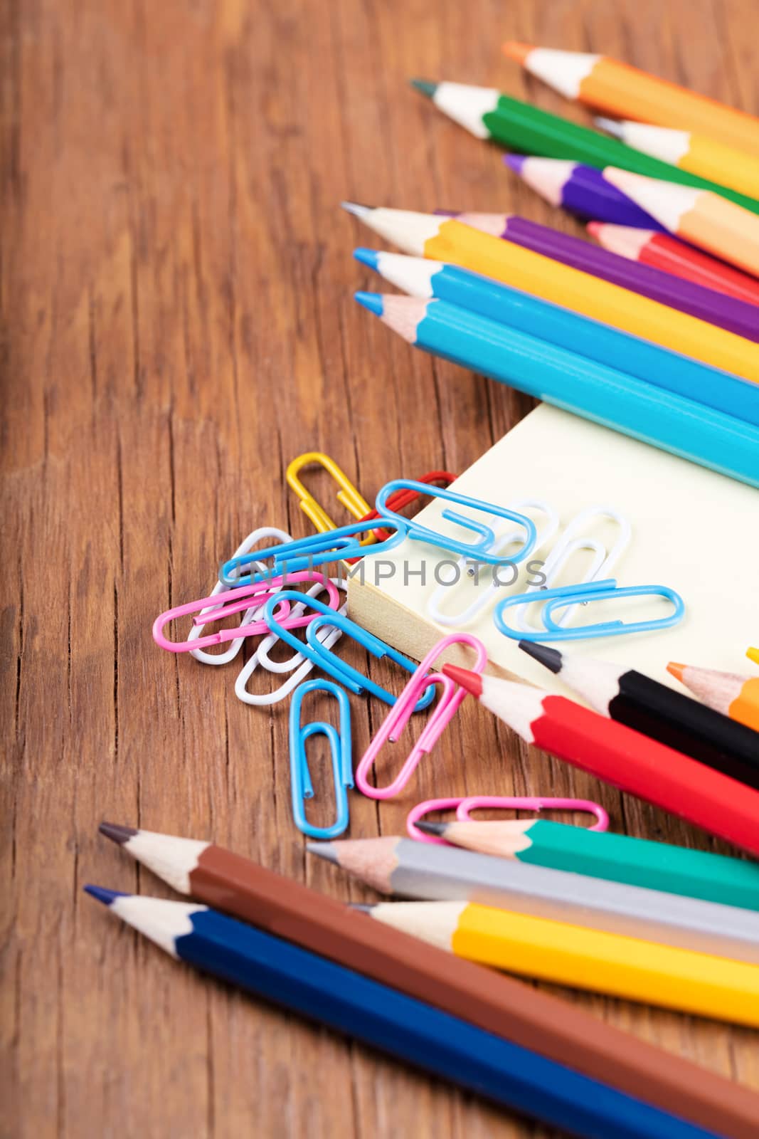 colored pencils and a notebook with paper clips