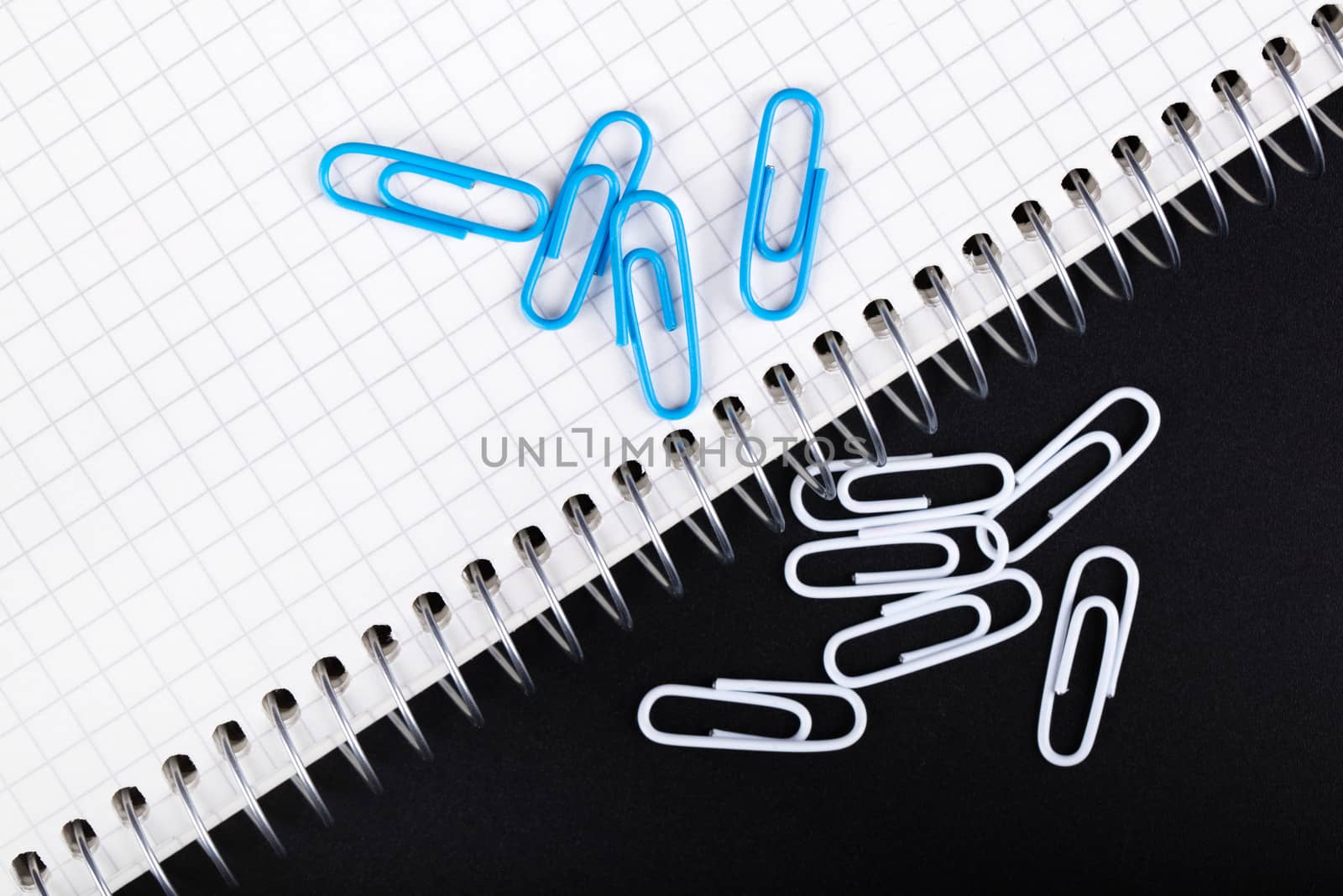 notebook and paper clips close-up on a black background