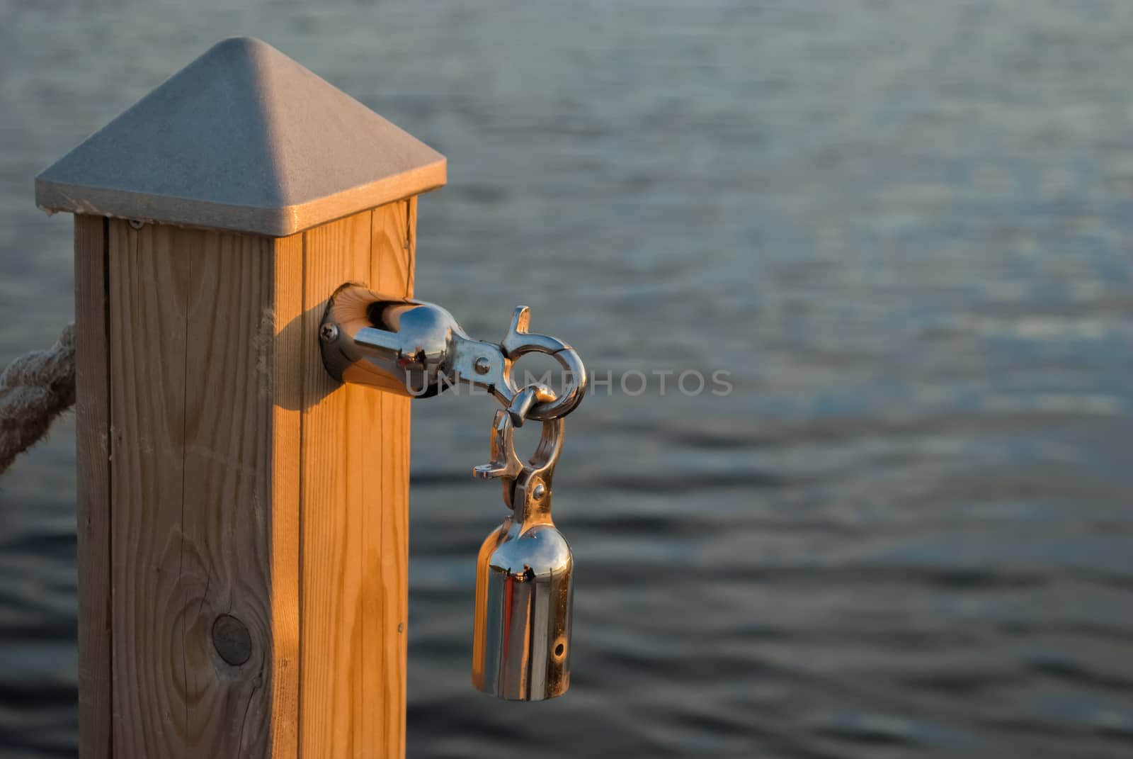 Carbine-lock chromed steel mounted on the column, the background of the water surface.