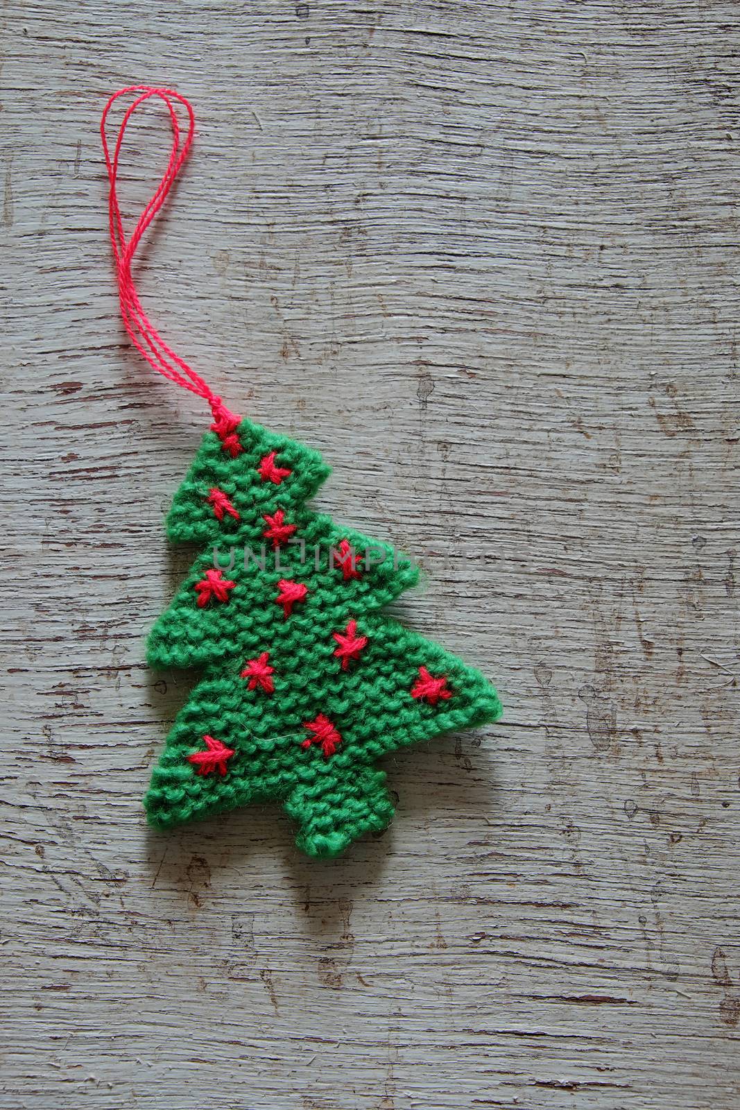 Knitted xmas tree on wooden background, Christmas trees knit from green yarn for holiday season