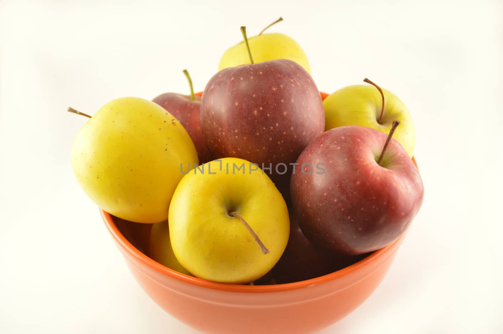 Red and white apple in an orange bowl