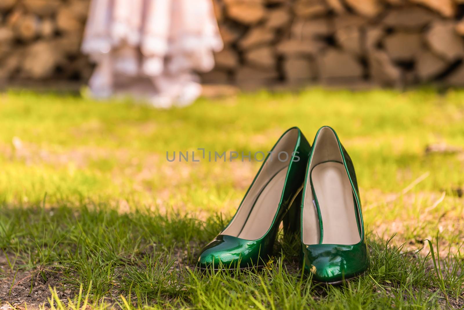 wedding emerald bridesmaid shoes on the green grass on the background of the dress