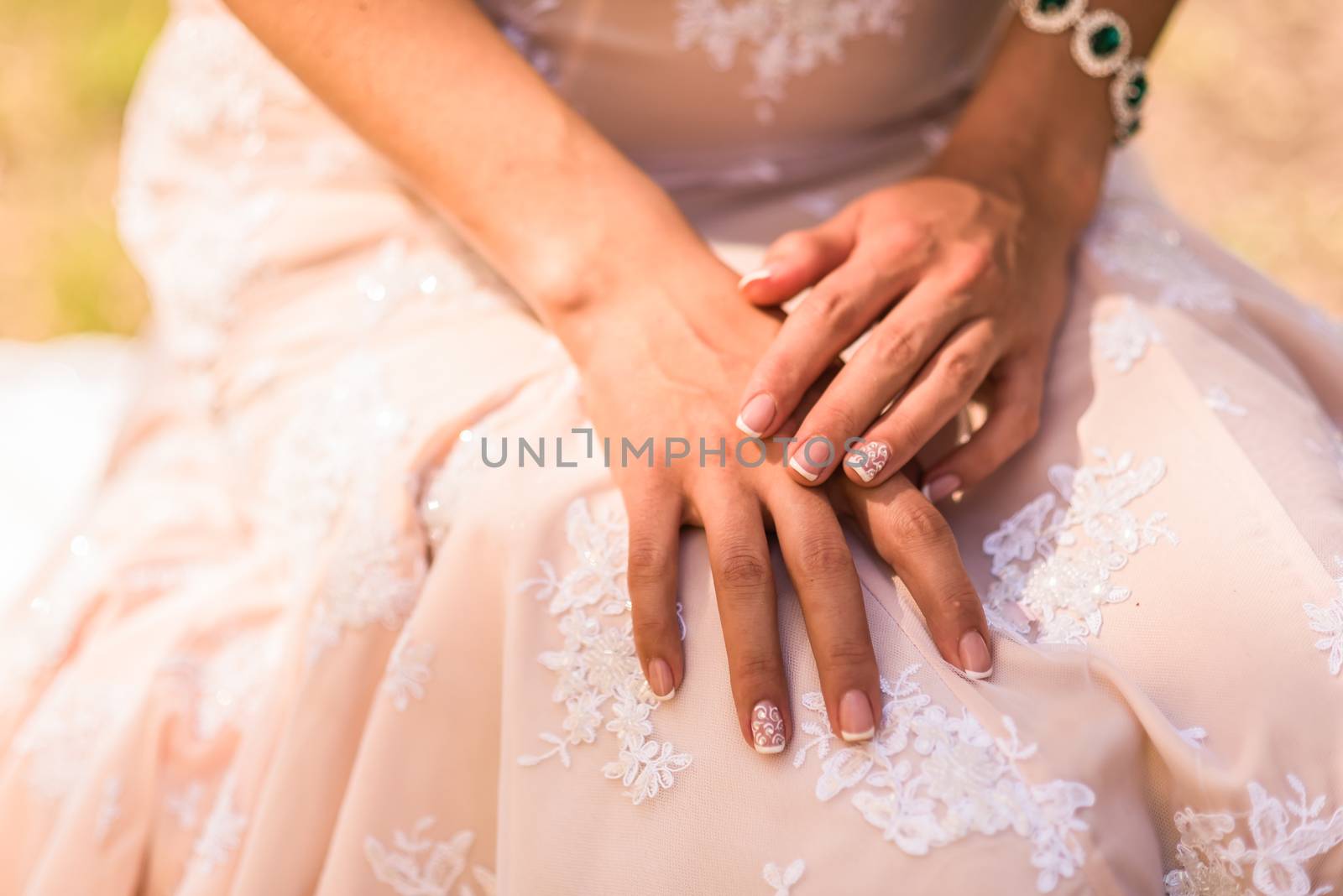 wedding manicure bride in gown, emerald jewelry bracelet