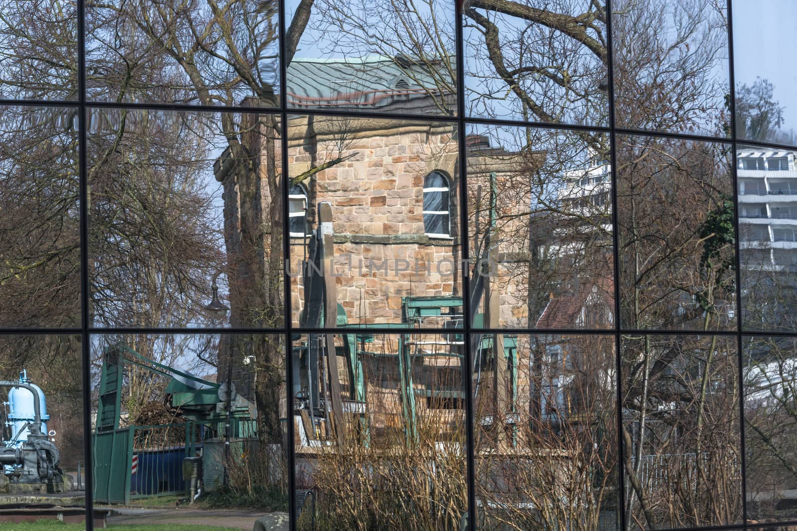 Beautiful glass building facade with reflections of surrounding buildings and nature.