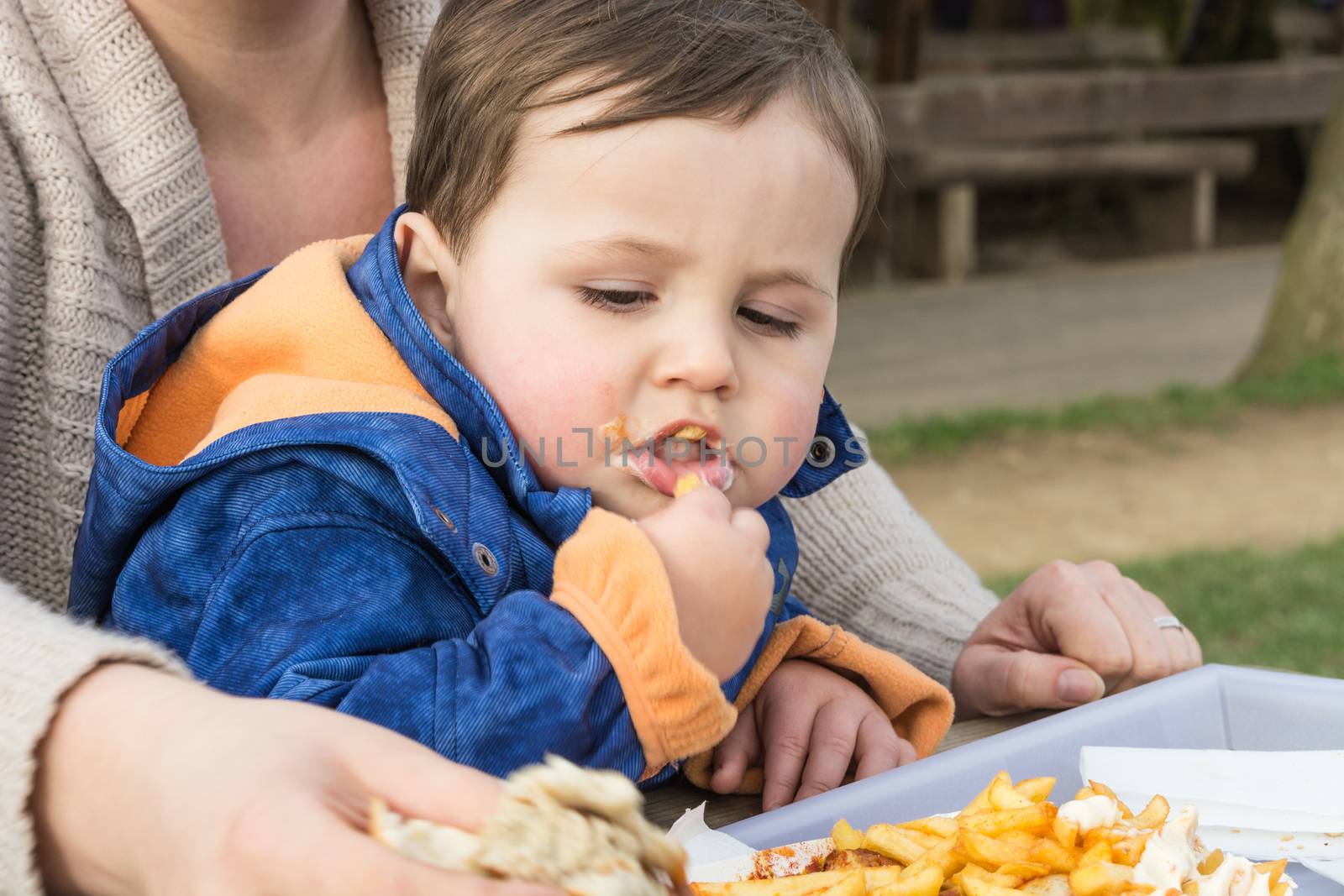 Child eats sausage with french fries by JFsPic