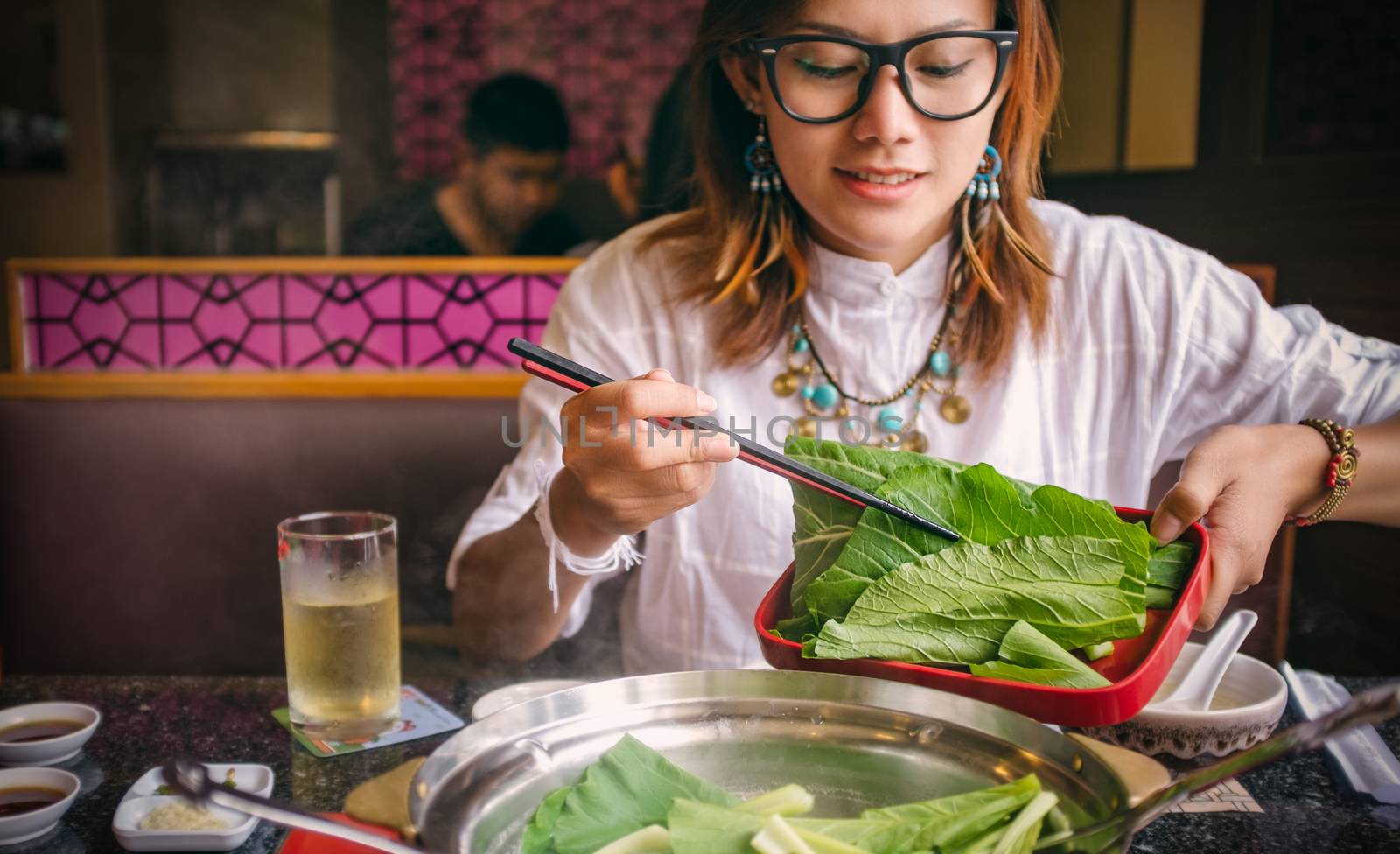 Asian women eating healthy vegetables happily. select Focus your chopsticks and vegetables